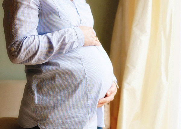 Schwangere Frau berührt ihren Bauch